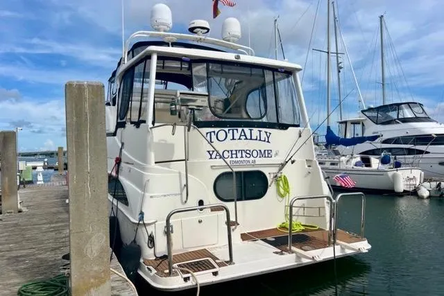 Slide: The Image of 2003 Silverton 43 Motor Yacht docked, named "Totally Yachtsome," with clear skies and marina backdrop. - 2
