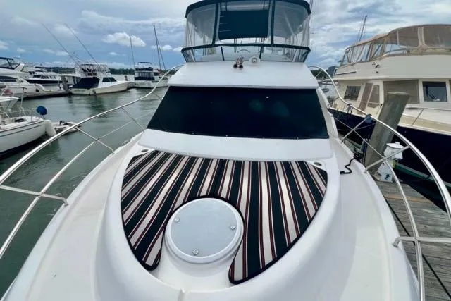 Slide: The Image of 2003 Silverton 43 Motor Yacht docked at marina, featuring striped deck cushion. - 20