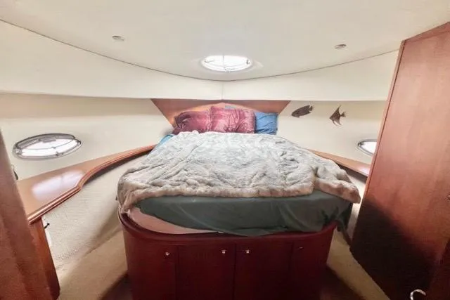 Slide: The Image of 2003 Silverton 43 Motor Yacht bedroom with cozy bed and porthole windows. - 32