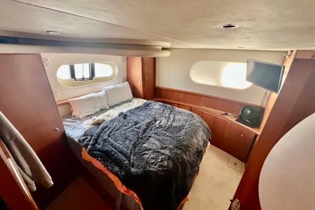 Slide: The Image of Cozy bedroom in 2003 Silverton 43 Motor Yacht with plush bedding and porthole windows. - 35