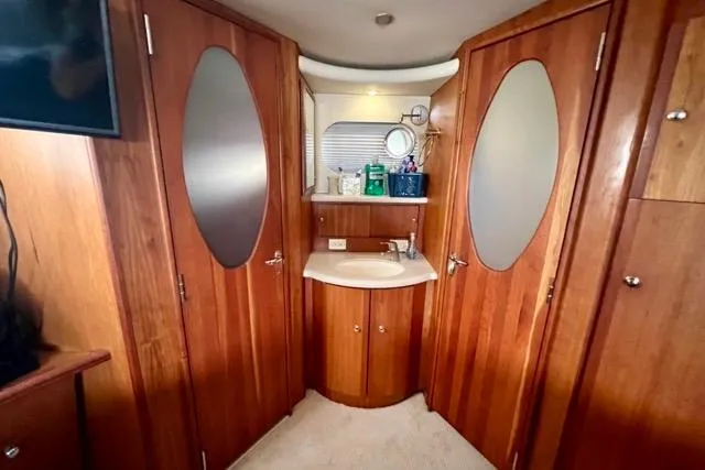 Slide: The Image of Interior of 2003 Silverton 43 Motor Yacht with wooden cabinetry and oval mirrors. - 36