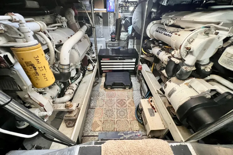 Slide: The Image of Engine room of a 2003 Silverton 43 Motor Yacht, featuring dual engines and maintenance tools. - 42