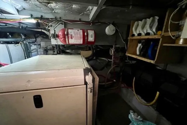Slide: The Image of Engine room of a 2003 Silverton 43 Motor Yacht with fire extinguisher and storage shelves. - 47