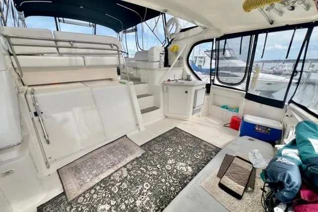 Slide: The Image of 2003 Silverton 43 Motor Yacht interior with seating, rugs, and marina view. - 5