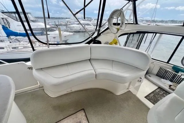 Slide: The Image of 2003 Silverton 43 Motor Yacht interior with white seating and marina view. - 9