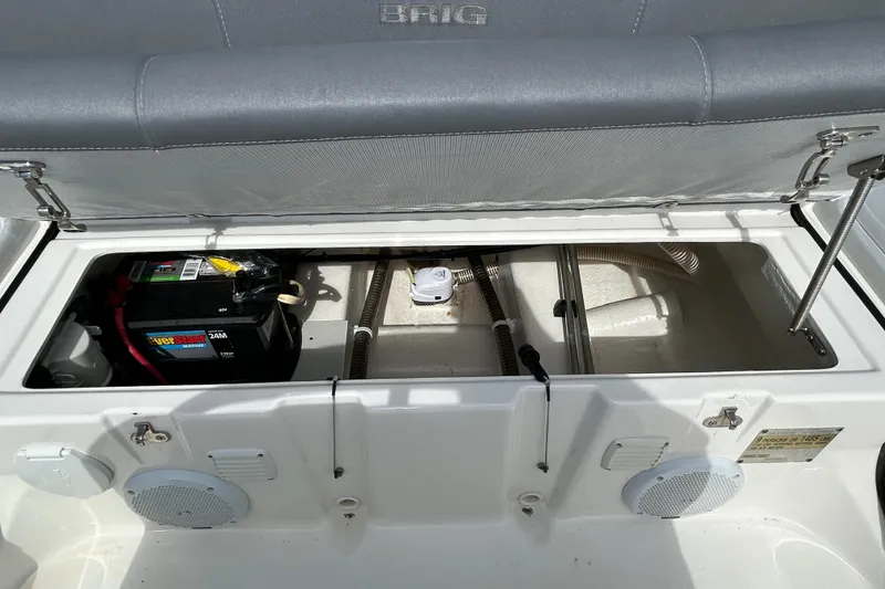 Slide: The Image of Open storage compartment of 2016 Brig Navigator 520 boat, showing battery and wiring. - 13