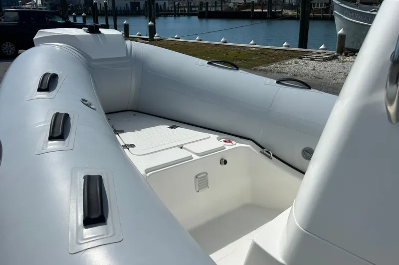 Slide: The Image of 2016 Brig Navigator 520 inflatable boat interior, docked near a marina. - 17