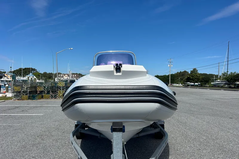 Slide: The Image of Front view of a 2016 Brig Navigator 520 boat on a trailer, under a clear blue sky. - 3