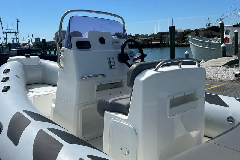 Slide: The Image of 2016 Brig Navigator 520 boat with steering console, docked at a marina under clear skies. - 7