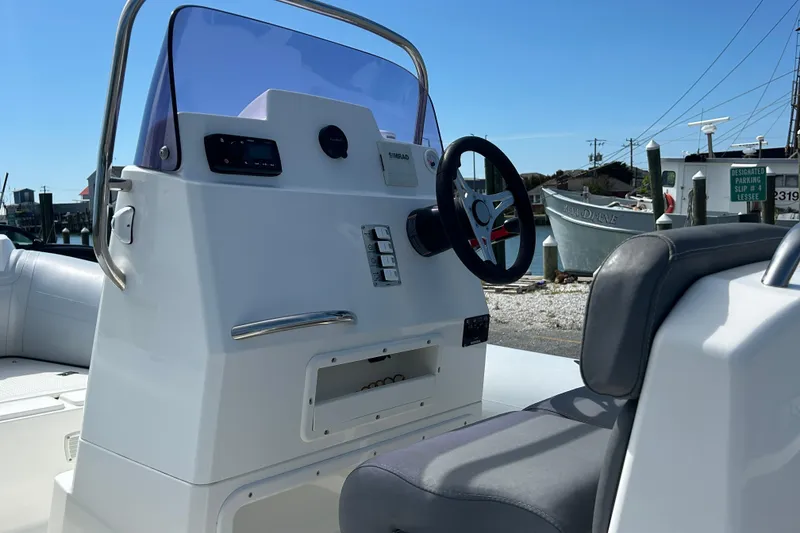 Slide: The Image of Steering console of a 2016 Brig Navigator 520 boat, featuring modern controls and seating. - 8