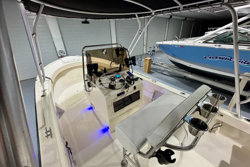 Slide: The Image of 2002 Parker 2100 Special Edition boat interior with steering console and seating in a garage. - 14