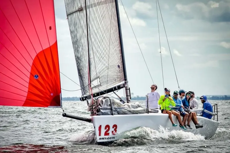 Slide: The Image of Sailing team on 2005 Melges 32 with vibrant red sail on open water. - 3