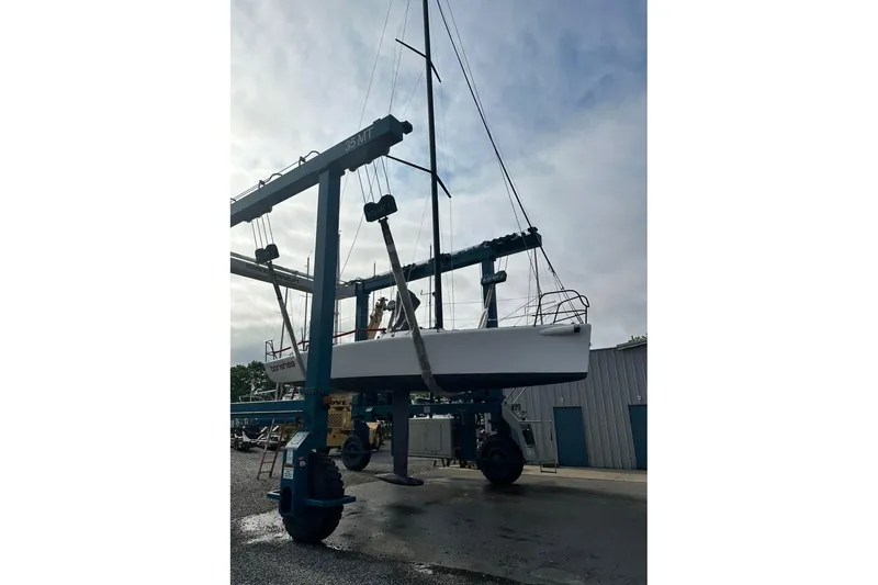 Slide: The Image of 2005 Melges 32 sailboat being lifted by a crane at a marina. - 6