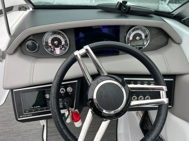 Slide: The Image of Dashboard of a 2022 Four Winns H260 boat with steering wheel. - 12