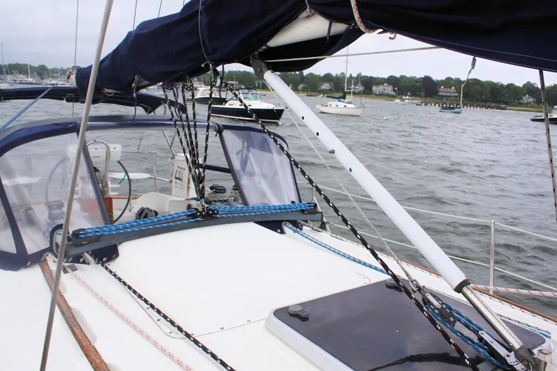 Slide: The Image of Sailboat deck view of 1991 Ericson 380, featuring rigging and marina backdrop. - 21