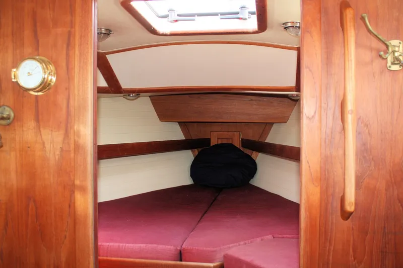 Slide: The Image of Cozy cabin interior of 1991 Ericson 380 sailboat with wooden finish and maroon cushions. - 25