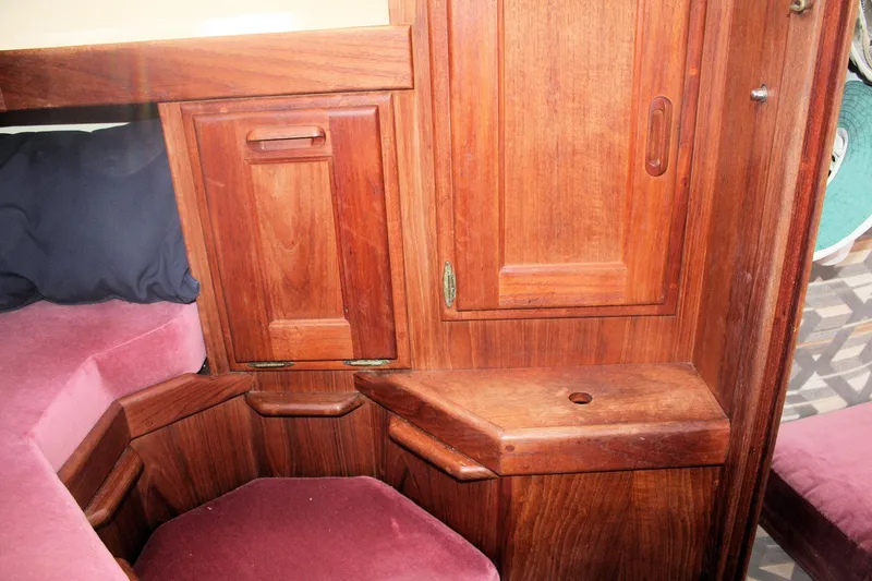 Slide: The Image of Interior of a 1991 Ericson 380 sailboat with wooden cabinetry and pink cushions. - 28