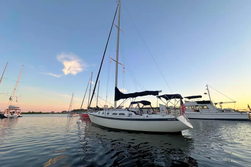 Slide: The Image of Sailboats anchored at sunset, featuring a 1993 Ericson 38-200 model on calm waters. - 3