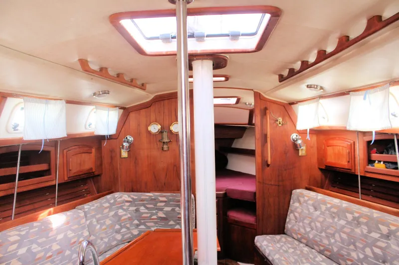 Slide: The Image of Interior of a 1991 Ericson 380 sailboat with wood paneling and cozy seating. - 31