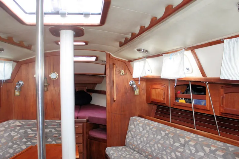 Slide: The Image of Interior of a 1991 Ericson 380 sailboat with wood paneling and cozy seating. - 34