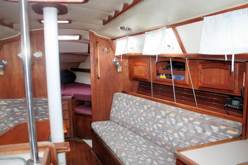 Slide: The Image of Interior of a 1991 Ericson 380 sailboat with wood paneling and patterned seating. - 35