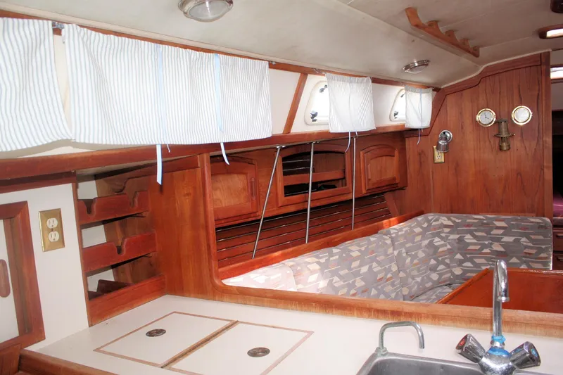 Slide: The Image of Interior of a 1991 Ericson 380 sailboat with wood paneling and compact kitchen area. - 36