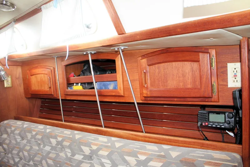Slide: The Image of Interior of a 1991 Ericson 380 sailboat with wooden cabinets and radio equipment. - 38