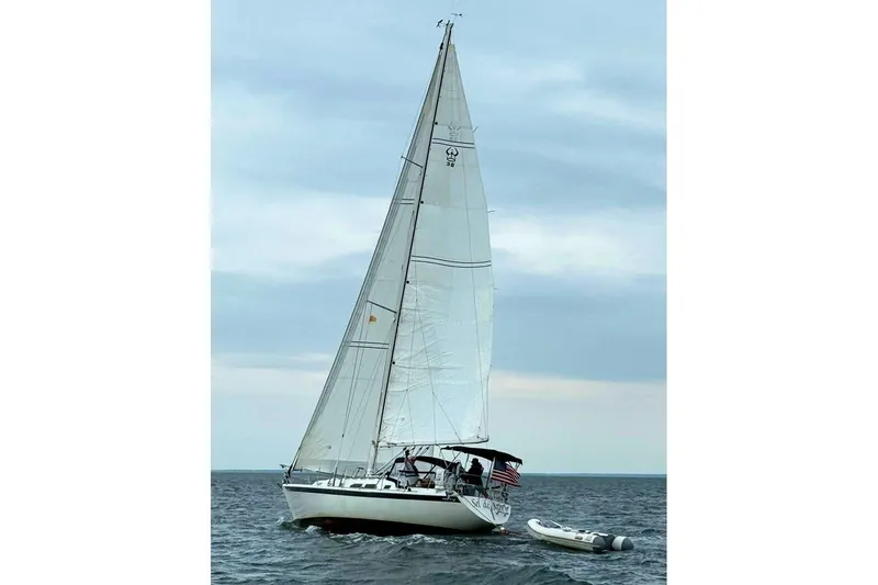 Slide: The Image of Sailing yacht Ericson 38-200, 1993 model, cruising on open water with a dinghy. - 4