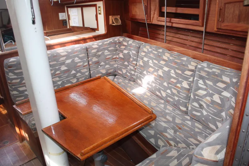 Slide: The Image of 1991 Ericson 380 sailboat interior with patterned seating and wooden table. - 41