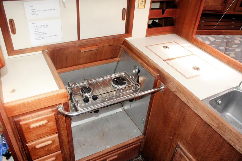 Slide: The Image of 1991 Ericson 380 yacht kitchen with wooden cabinetry, stove, and sink. - 45