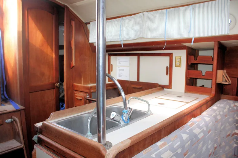 Slide: The Image of Interior of a 1991 Ericson 380 sailboat featuring a compact kitchen area. - 46
