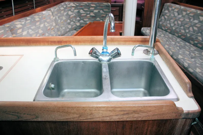 Slide: The Image of Double sink in 1991 Ericson 380 yacht galley with patterned seating in background. - 47
