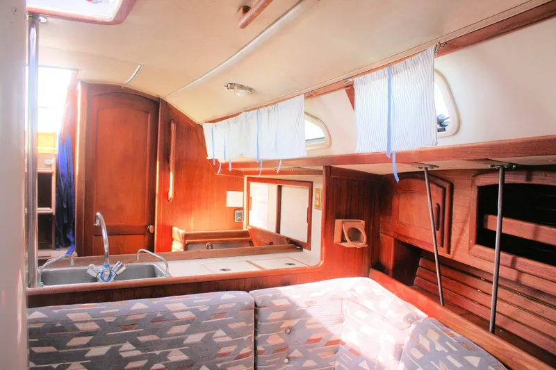 Slide: The Image of Interior of a 1991 Ericson 380 sailboat with wooden cabinetry and seating area. - 49