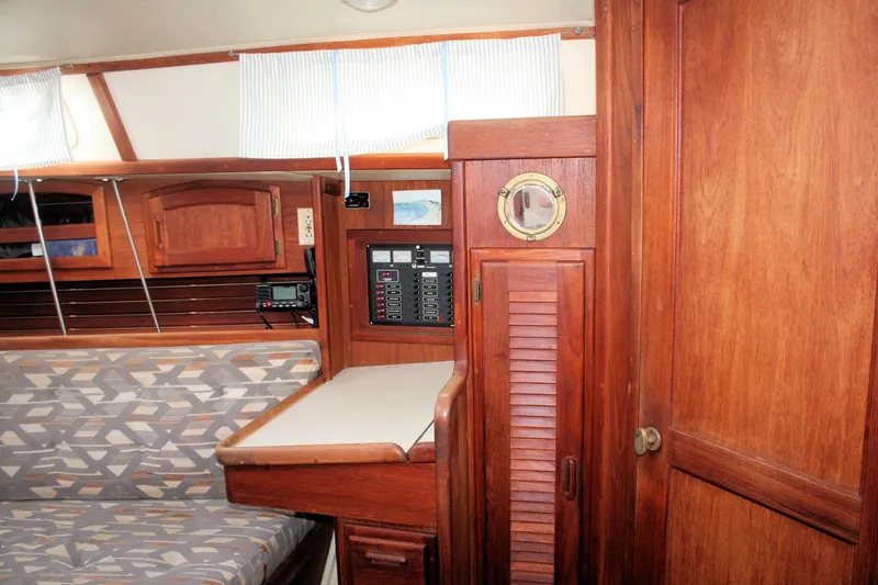 Slide: The Image of Interior of a 1991 Ericson 380 sailboat with wooden cabinetry and seating area. - 54