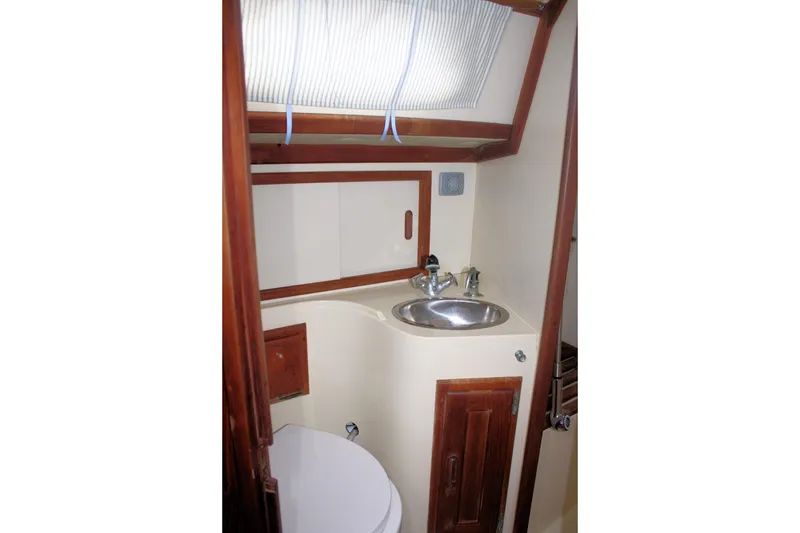 Slide: The Image of Compact bathroom in a 1991 Ericson 380 sailboat with sink and wooden accents. - 59