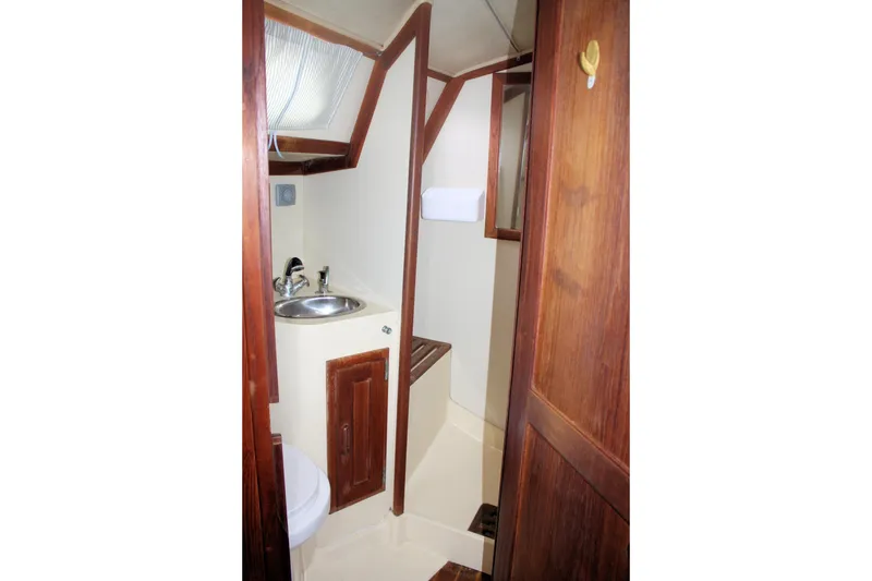 Slide: The Image of 1991 Ericson 380 yacht bathroom with wooden cabinetry and compact sink area. - 61