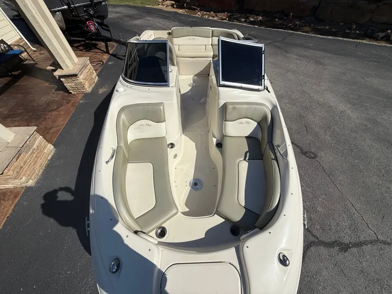 Slide: The Image of 2006 Sea Ray 200 Sundeck boat with beige seating on asphalt. - 18