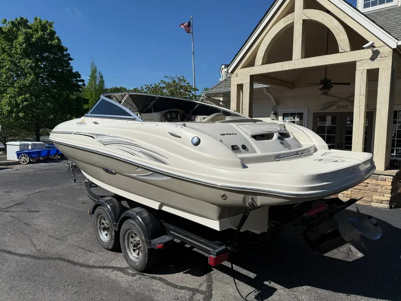 Slide: The Image of 2006 Sea Ray 200 Sundeck boat on trailer in front of building. - 21