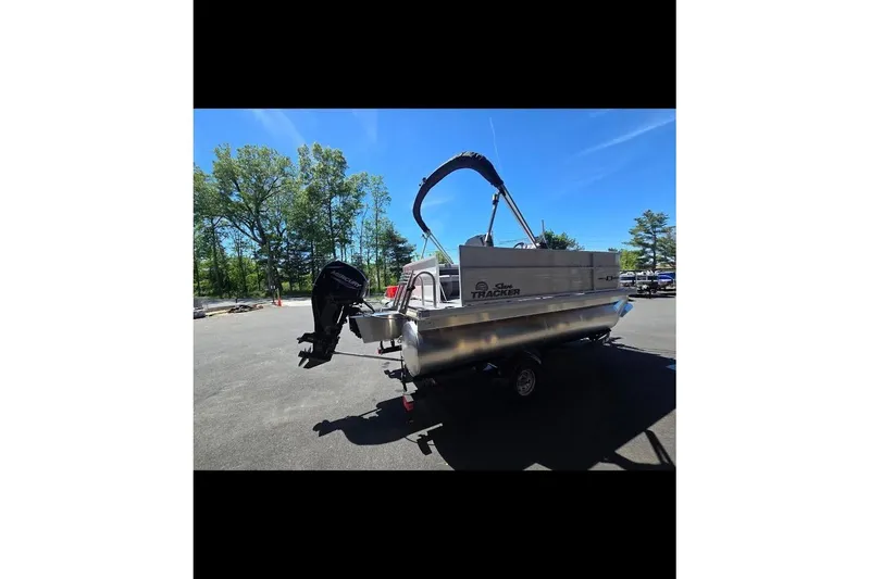 Slide: The Image of 2026 Sun Tracker Party Barge 16 DLX pontoon boat on trailer, parked outdoors. - 3
