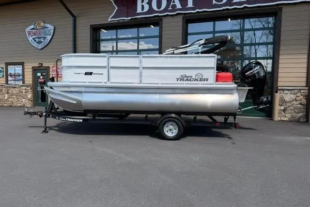 The Image of 2026 Sun Tracker Party Barge 16 DLX pontoon boat on trailer outside dealership. - 0