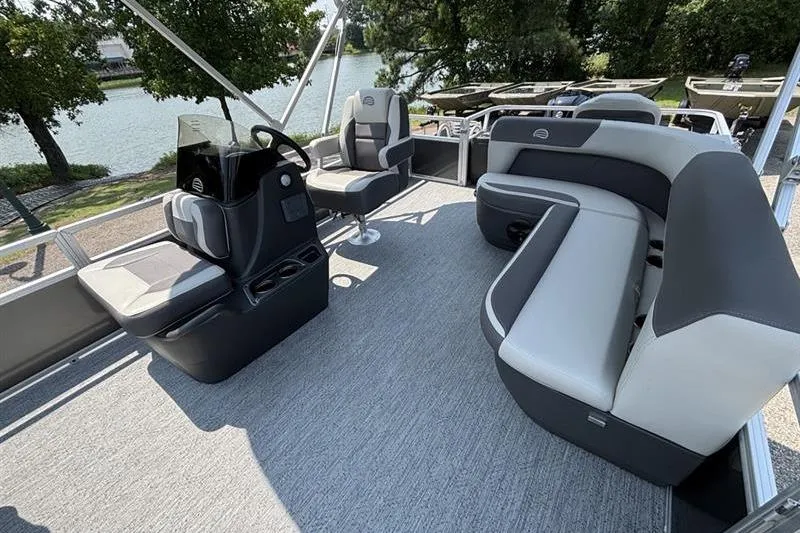 Slide: The Image of 2026 Sun Tracker Bass Buggy 18 DLX pontoon boat interior with seating and steering console. - 17