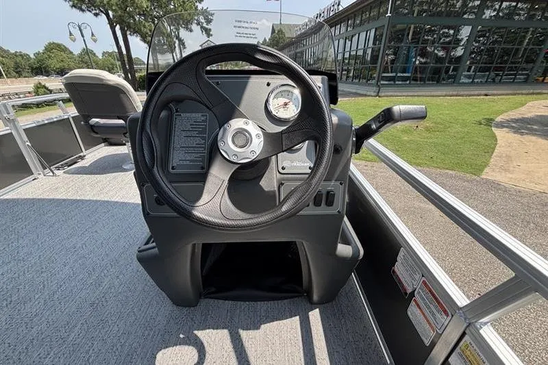 Slide: The Image of 2026 Sun Tracker Bass Buggy 18 DLX steering console with gauge and controls. - 14