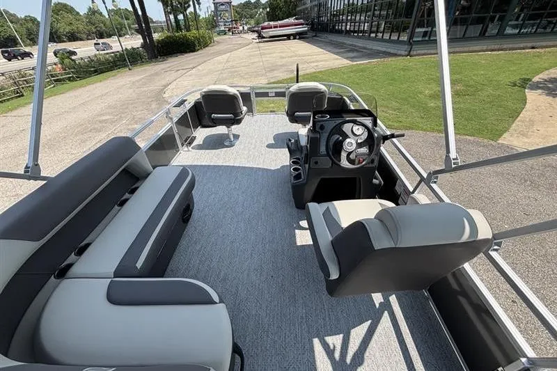 Slide: The Image of 2026 Sun Tracker Bass Buggy 18 DLX pontoon boat interior with seating and steering console. - 20