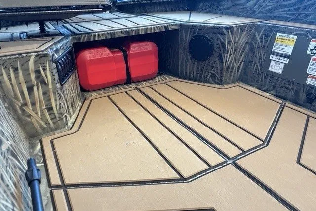 Slide: The Image of 2026 Tracker Grizzly 1650 T Prairie Wings Edition boat interior with camouflage design and red fuel tanks. - 4