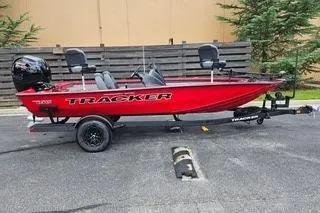 The Image of 2026 Tracker Pro Team 195 boat in vibrant red on a trailer, parked outdoors. - 0