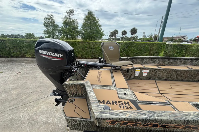 Slide: The Image of 2026 Tracker Grizzly 1756 T Marsh boat with Mercury outboard motor, parked outdoors. - 50