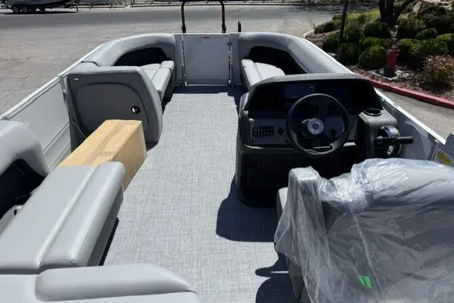 Slide: The Image of 2026 Sun Tracker Party Barge 18 DLX interior with gray seating and steering console. - 10