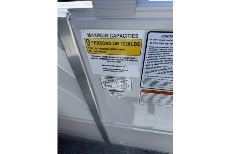 Slide: The Image of Capacity label on 2026 Sun Tracker Party Barge 18 DLX, showing 9 persons or 1220 lbs limit. - 11
