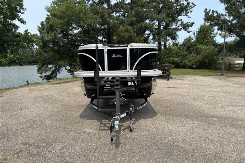 Slide: The Image of 2026 Sun Tracker Party Barge 22 RF XP3 on trailer, parked near a lake. - 1