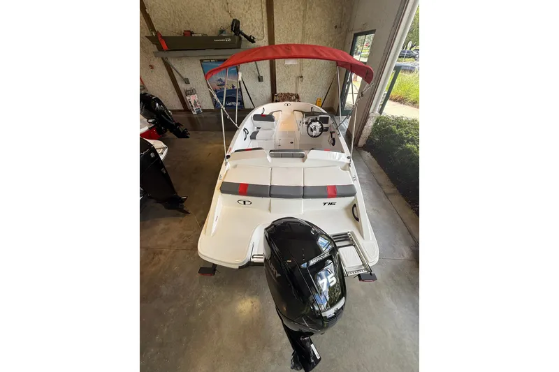 Slide: The Image of 2026 Tahoe T16 boat with red canopy and Mercury outboard motor in showroom. - 3